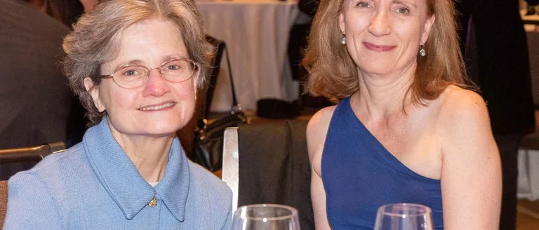 Carol Mangione and female colleague sitting at a celebration dinner.