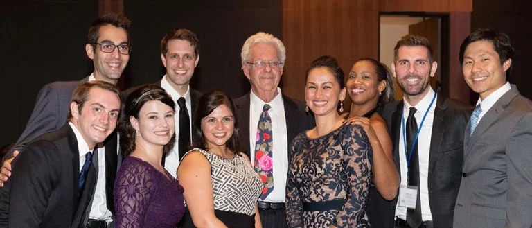 Group of male and female scholars dressed up and smiling for celebration ceremony.
