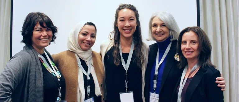 Group of female scholars gathered together at conference.