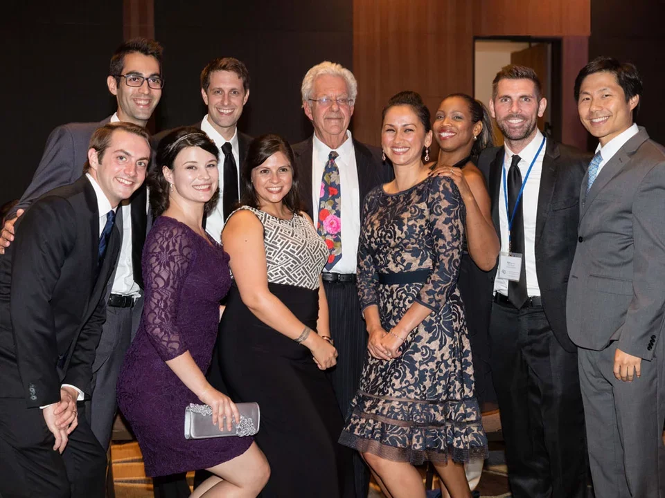 Group of male and female scholars dressed up and smiling for celebration ceremony.