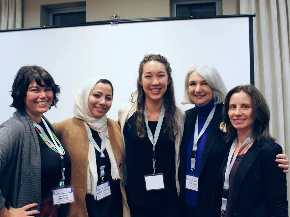 Group of female scholars gathered together at conference.