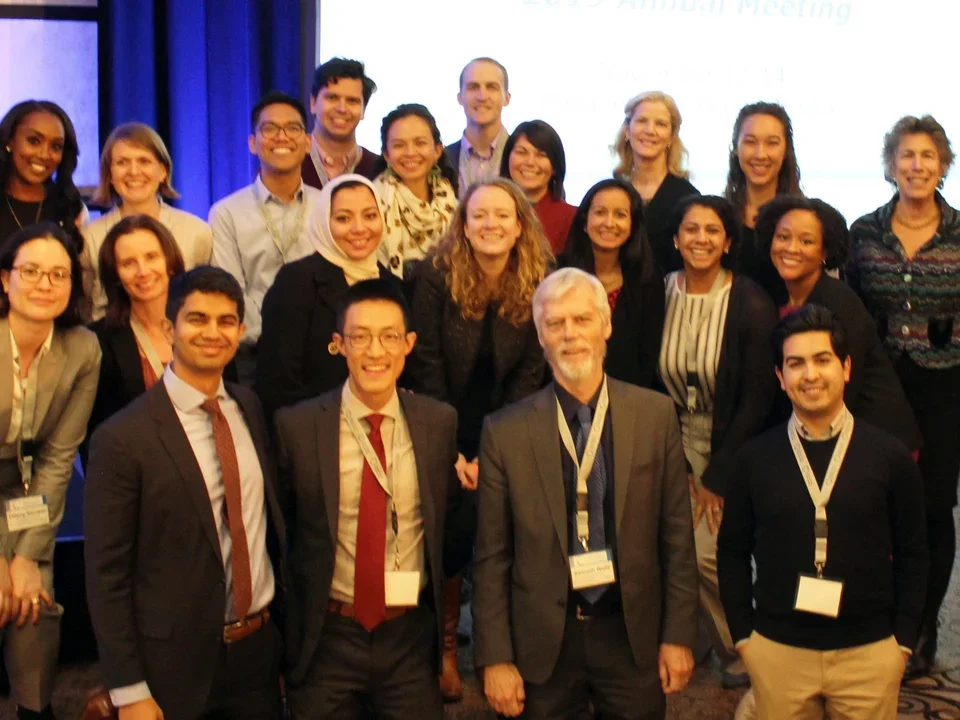 Group of men and women scholars in suits at awards convention.